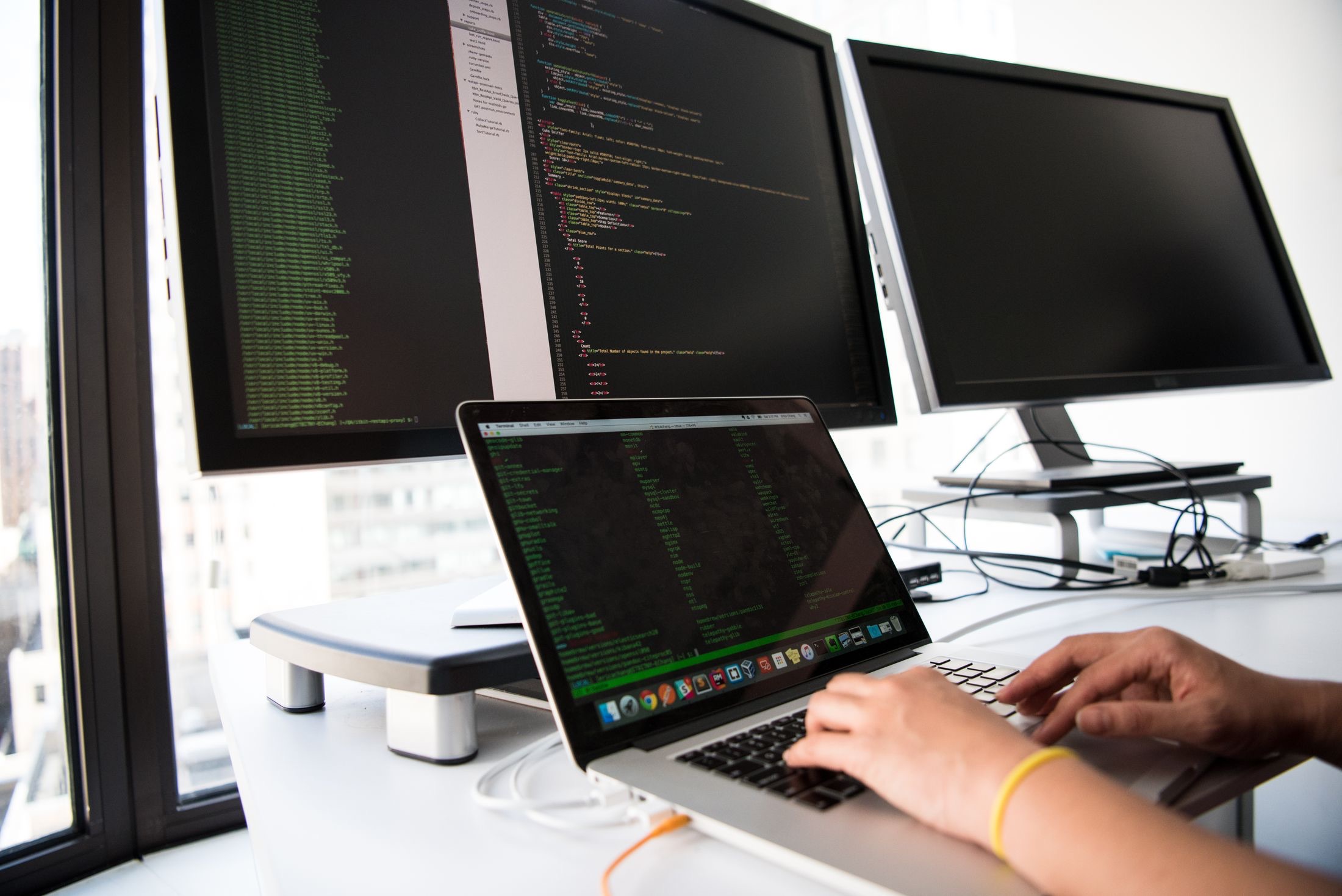 Developer at a multi-monitor workstation