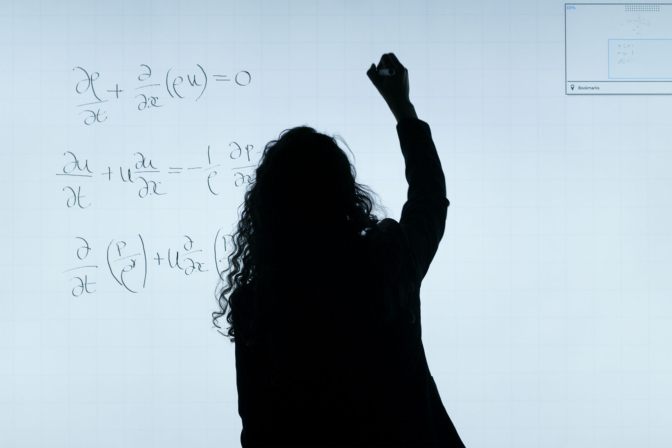 Engineer working through a problem on a glass board